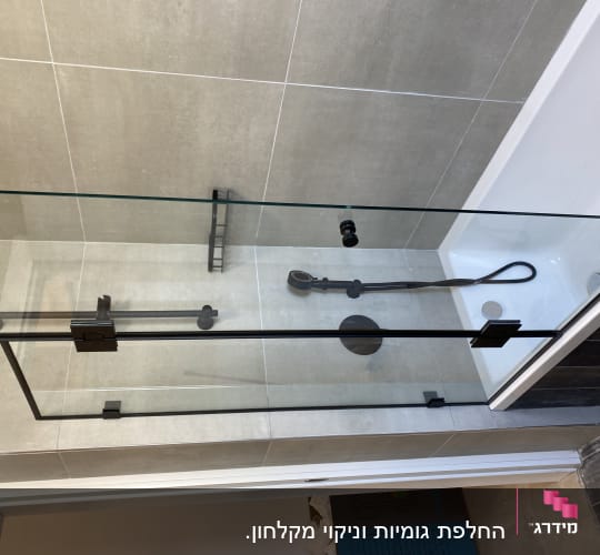 מקלחון זכוכית עם ראש מקלחת ידני ומדף קטן